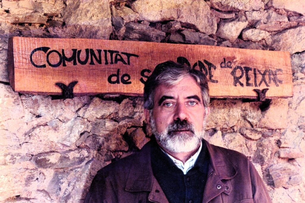 Josep Rius-Camps davant el cartell de la COmunitat de SAnt Pere de Reixac